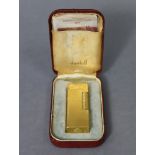 A Dunhill cigarette lighter in yellow-metal case, & with carrying case.