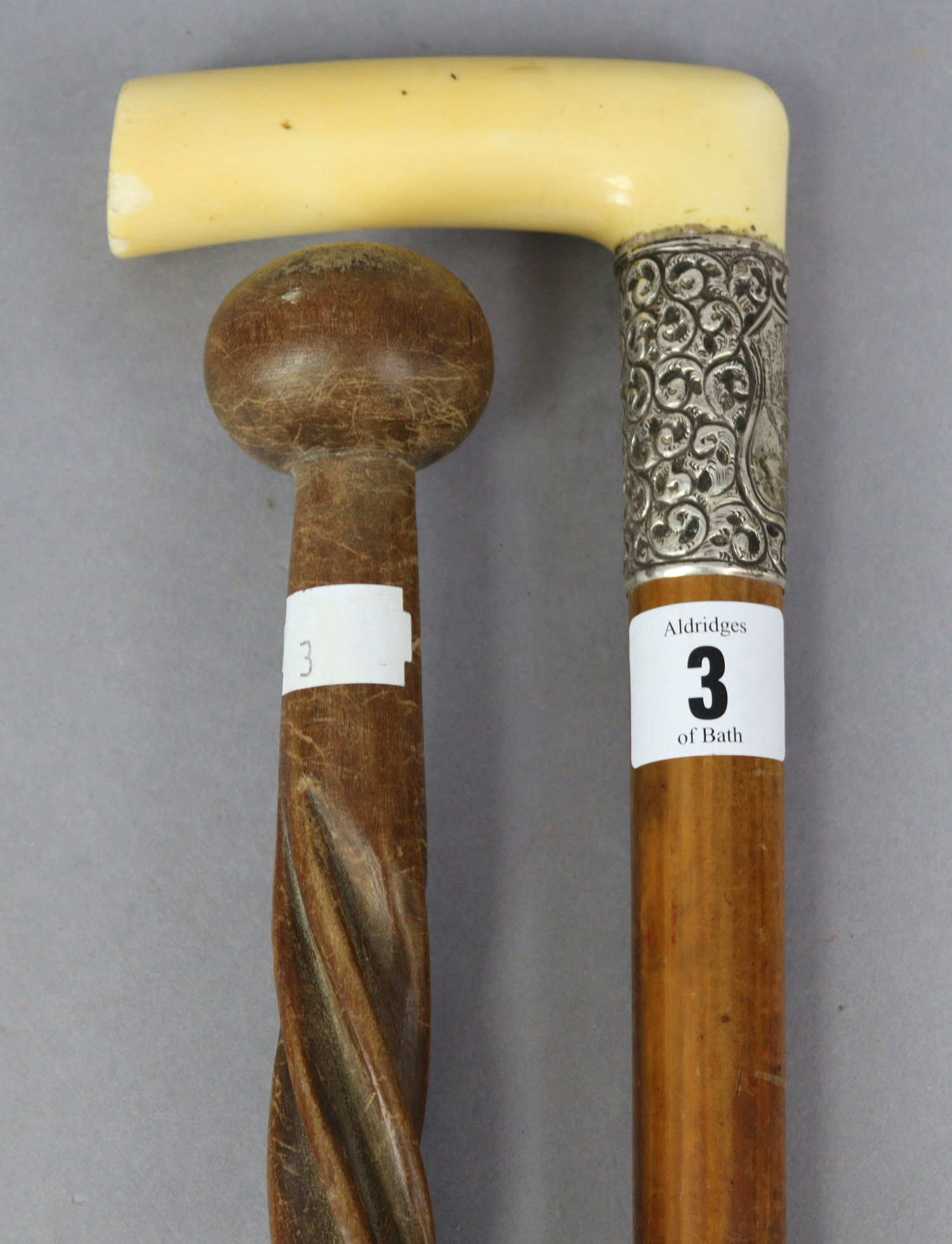 An Edwardian gent’s walking cane with ivory handle, & with embossed white-metal collar, 36” high; &