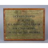 A brass rectangular Inn sign “Licenses To Sell By Retail…”, mounted on a mahogany board, 9½” x