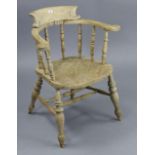 A spindle-back captain’s chair with hard seat, & on turned legs with spindle stretchers.