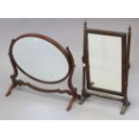 An early 20th century mahogany rectangular swing toilet mirror, in ring-turned supports, 12” wide