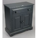 A dark blue painted pine dwarf cupboard, fitted frieze drawer above a pair of panel doors, & on