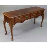 A reproduction walnut lowboy, fitted two frieze drawers with shaped apron, on short cabriole