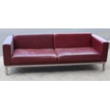 A crimson leather three-seater settee on chrome short square legs, 81” long.