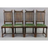 A set of four 1930’s oak rail-back dining chairs with padded drop-in seats, & on barley-twist legs