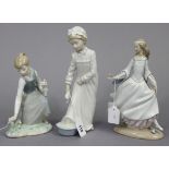 A Lladro Nao porcelain ornament in the form of a standing girl figure with a scrubbing brush in