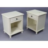 A pair of white-finish bedside cabinets, each fitted with a frieze drawer above an open recess, 17½”