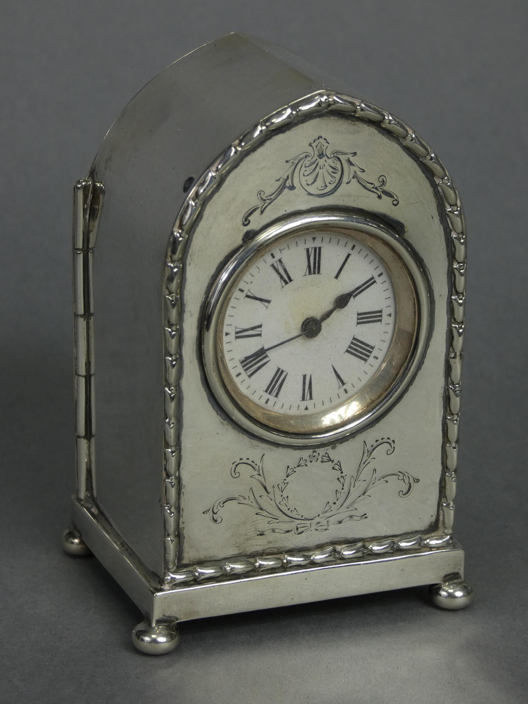 An Edwardian silver lancet-cased timepiece with raised husk border & engraved leaf-scroll