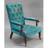 A Victorian mahogany easy chair with tall buttoned back, open arms, & sprung seat upholstered