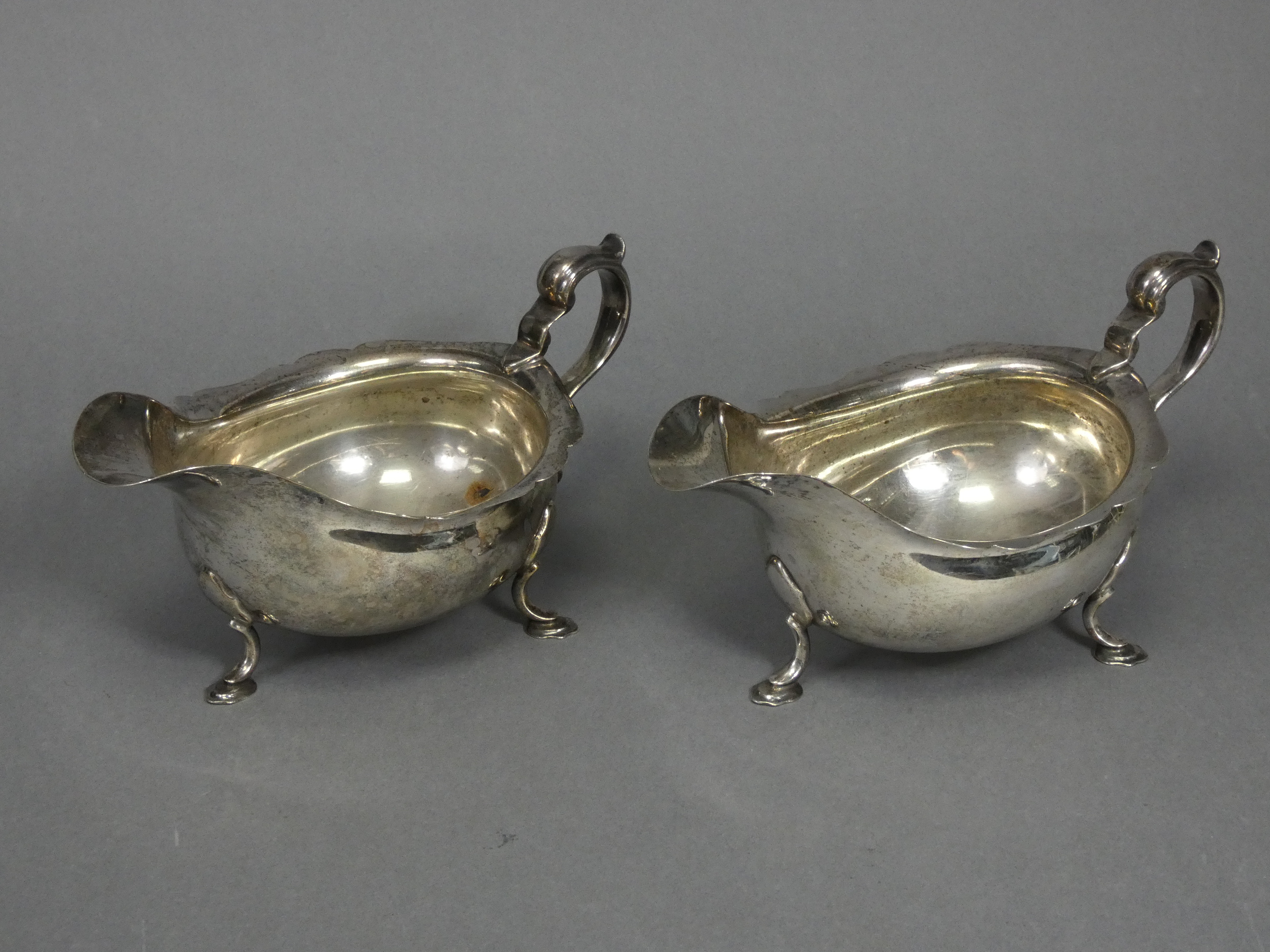 A pair of Georgian-style silver sauce boats with card-cut rims & scroll handles, each on three splay - Image 3 of 4