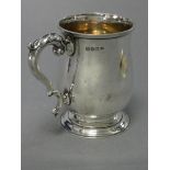 A George V silver half-pint baluster mug in the 18th century style, with foliate scroll handle,