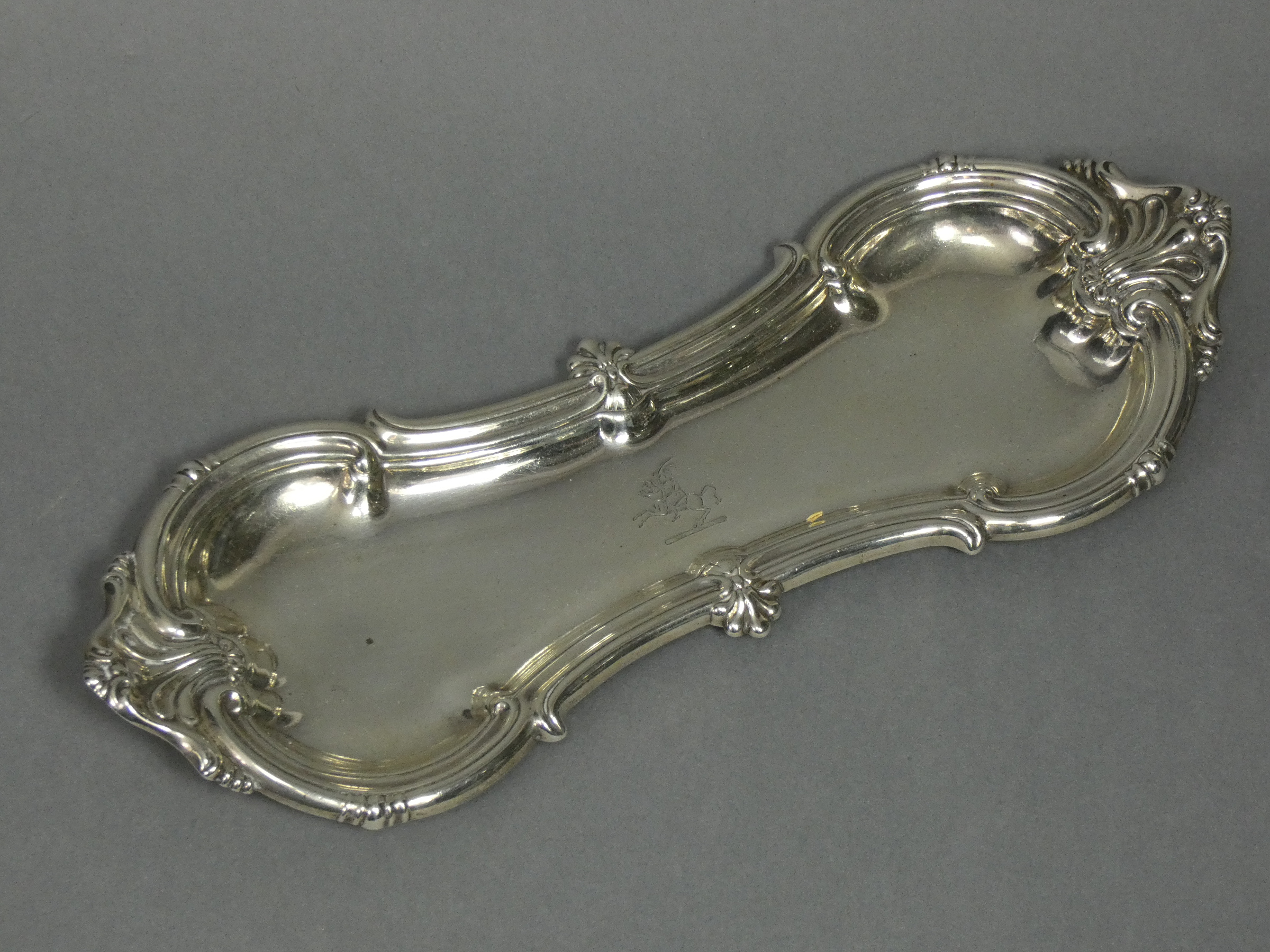 A William IV silver pen or snuffers tray of waisted oblong shape with raised scroll border, 9¾”