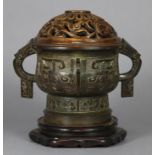 A Chinese bronze censer in the archaic style, the rounded body with stylised animal side handles,