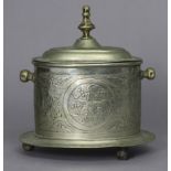 An eastern white metal oval tea caddy with embossed stylised decoration, hinged lid, & on three