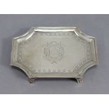 A George III silver teapot stand of rectangular shape with re-entrant corners & engraved borders, an