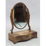 A regency mahogany toilet glass with oval mirror plate on shaped supports above a three-drawer