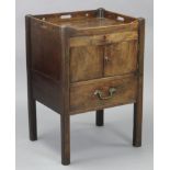 A Georgian mahogany bedside cupboard, adapted from a commode, with pierced tray-top gallery above