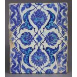 A 16th century IZNIK BLUE & WHITE TILE, with stylised foliate decoration in turquoise & deep blue on