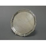 A silver card tray with raised shaped border & gadrooned rim, on four pad feet, 6¼” diam., Chester