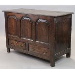 An 18th century oak mule chest, with arched three-panel front above two short drawers with brass