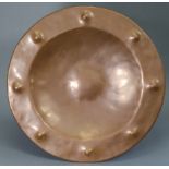 An Arts & Crafts copper large shallow bowl, with hammered decoration to the wide rim, 17½” diam.