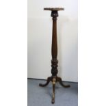 A mahogany torchere with raised moulded edge to the hexagonal top, on carved &baluster-turned column