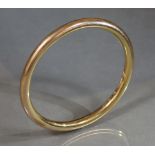 An early 20th century 15ct. gold stiff ‘slave’ bangle, internal diam. 3” (20.5 gm); sold with