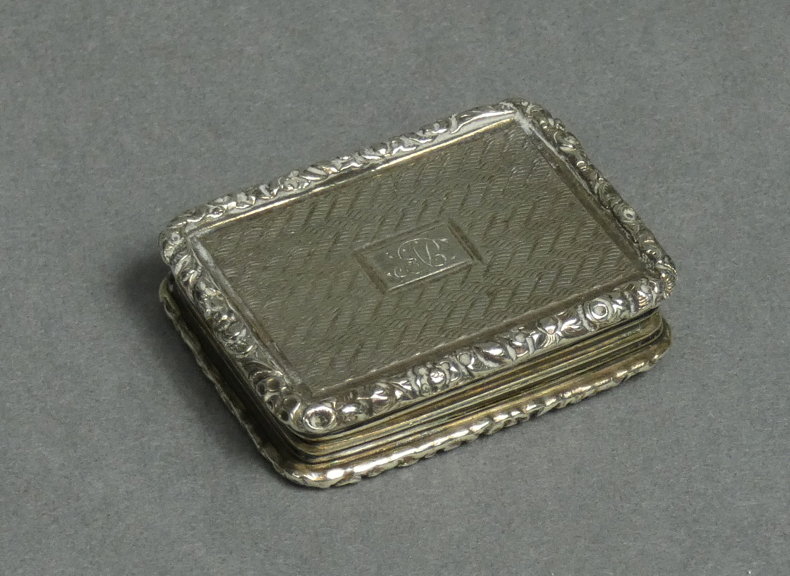 A George IV silver vinaigrette of rectangular shape, engine-turned decoration & carved scroll