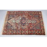 A Persian pattern rug, of rust red ground, with all over repeating geometric design & central