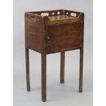 A Georgian mahogany bedside cupboard, with pierced tray top gallery above a cupboard enclosed by