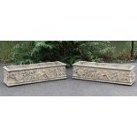 A pair of rectangular stone garden troughs, each with moulded classical decoration of dancing putti;