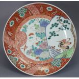 A Japanese Imari porcelain charger, decorated with panels of foliage & crane under a pine tree