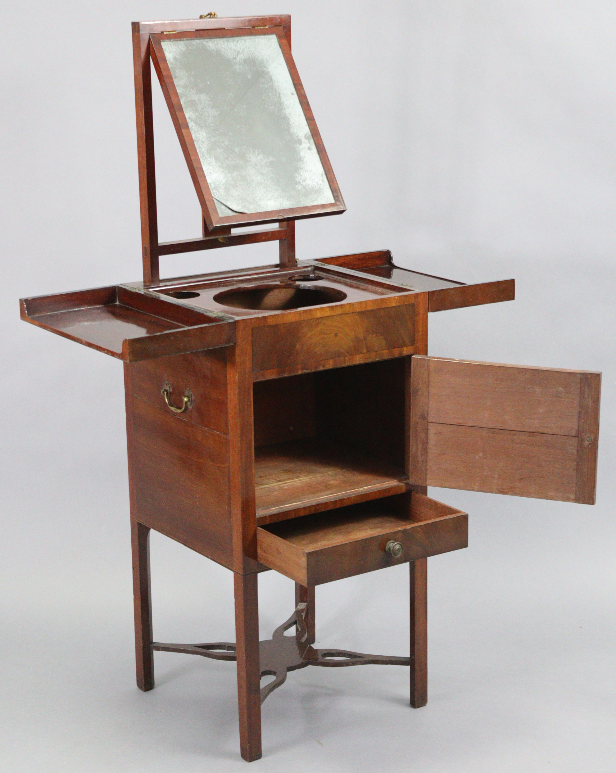 An early-mid 19th century mahogany washstand with envelope top, fitted with an adjustable rise-&-