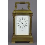 A large carriage clock in gilt-brass case with fluted Corinthian corner columns, the white enamel
