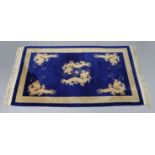 A Chinese rug of deep blue ground, with dragon decoration in archaistic border; “ x “