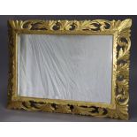 A rectangular bevelled wall mirror in carved & pierced giltwood leaf-scroll frame; 42” x 31”.