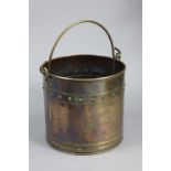 An early 20th century brass cylindrical coal bucket with copper rivets & overhang handle; 12” high x