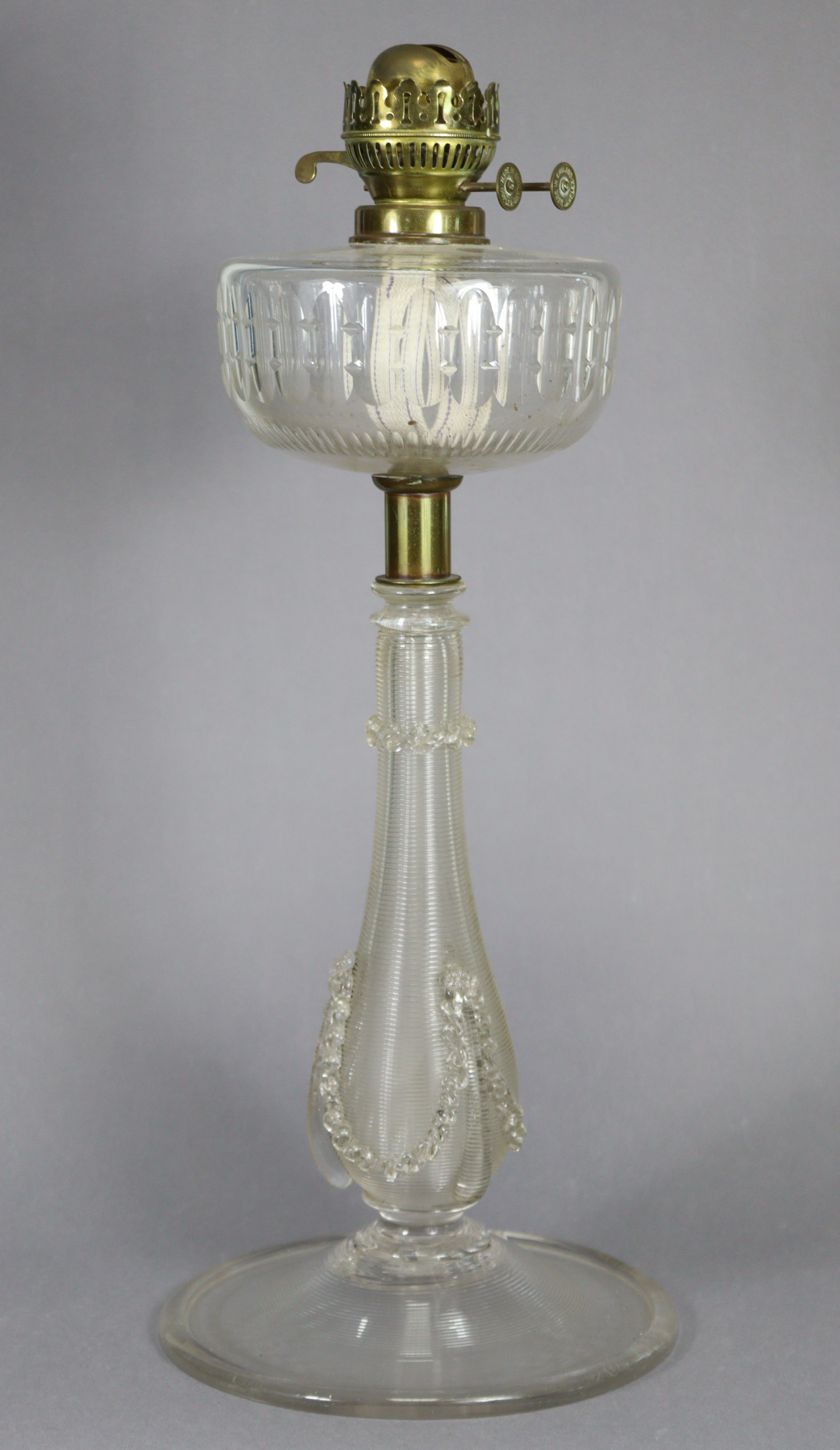 A Victorian large oil lamp with cut-glass reservoir, on ribbed baluster column & circular base