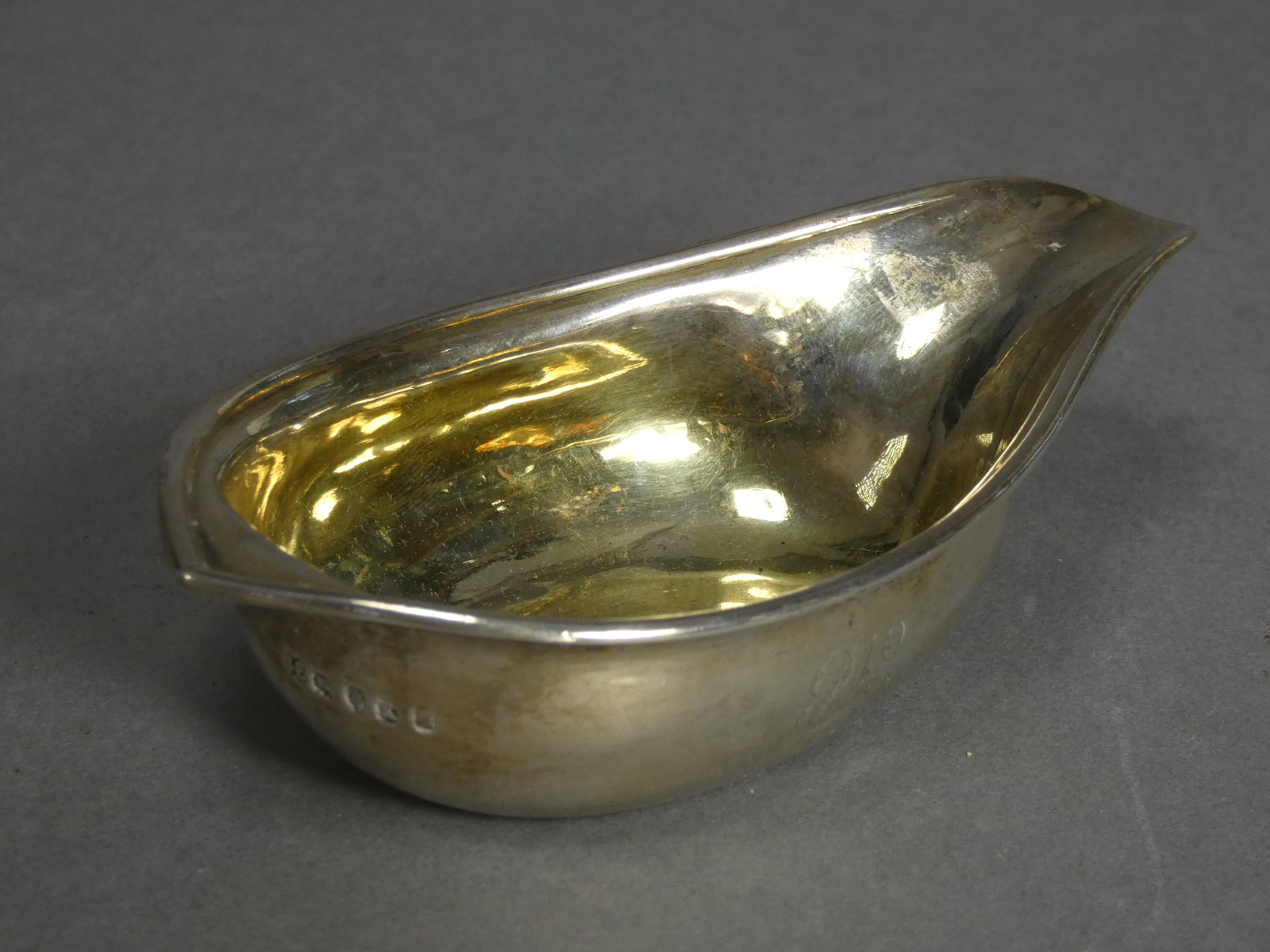 A George III silver pap boat with moulded rim, pointed end, & gilt interior, 5” long; London 1805,