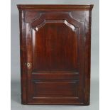 An 18th century mahogany & oak large hanging corner cupboard, fitted four shaped shelves enclosed by