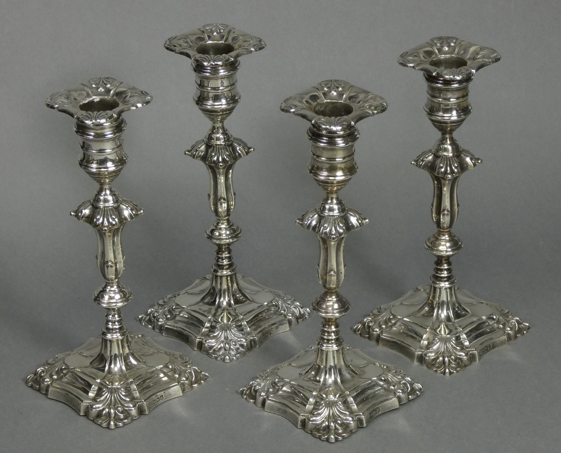 A set of four Edwardian silver candlesticks in the mid-18th century cast style, each with slender