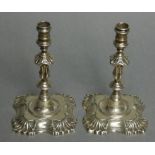 A pair of cast silver tapersticks in the mid-18th century style, with reel-shaped nozzles, slender