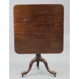 A George III mahogany tripod table, the one-piece rectangular tilt-top with rounded corners, on “