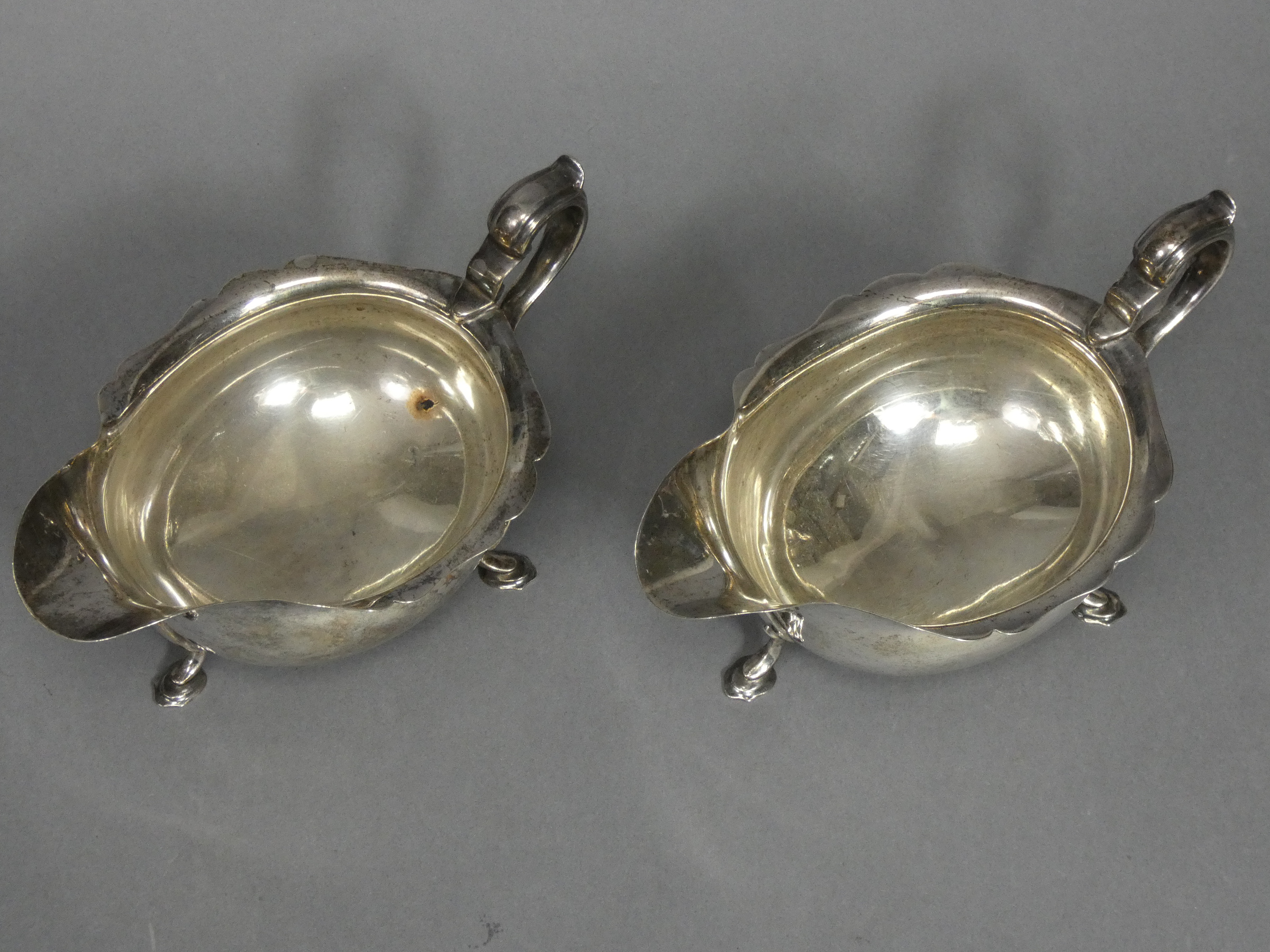 A pair of Georgian-style silver sauce boats with card-cut rims & scroll handles, each on three splay - Image 4 of 4