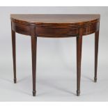 A 19th century inlaid mahogany demi-lune tea table with fold-over top supported by a gate-leg, on