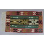 A Kilim rug of pink, green, & ochre ground with central geometric panel in a wide butterfly