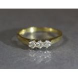 An 18ct. gold ring set row of three small diamonds; size: L, weight: 2.3 gm.
