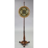 An early Victorian rosewood pole banner screen inset circular needlework panel, on baluster turned