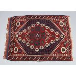 A small Persian pattern rug of madder ground, with all-over repeating geometric design & lozenge