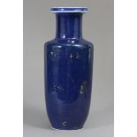 A Chinese porcelain rouleau vase, of powder-blue ground with traces of gilt decoration, Kangxi six-
